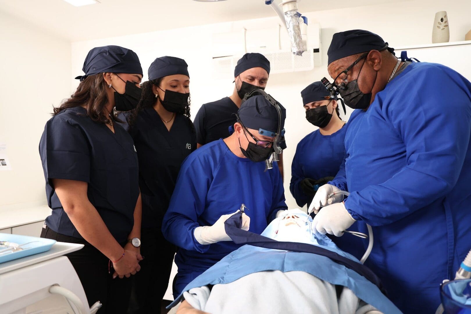 Faculty and participants around the chair during a live implant case